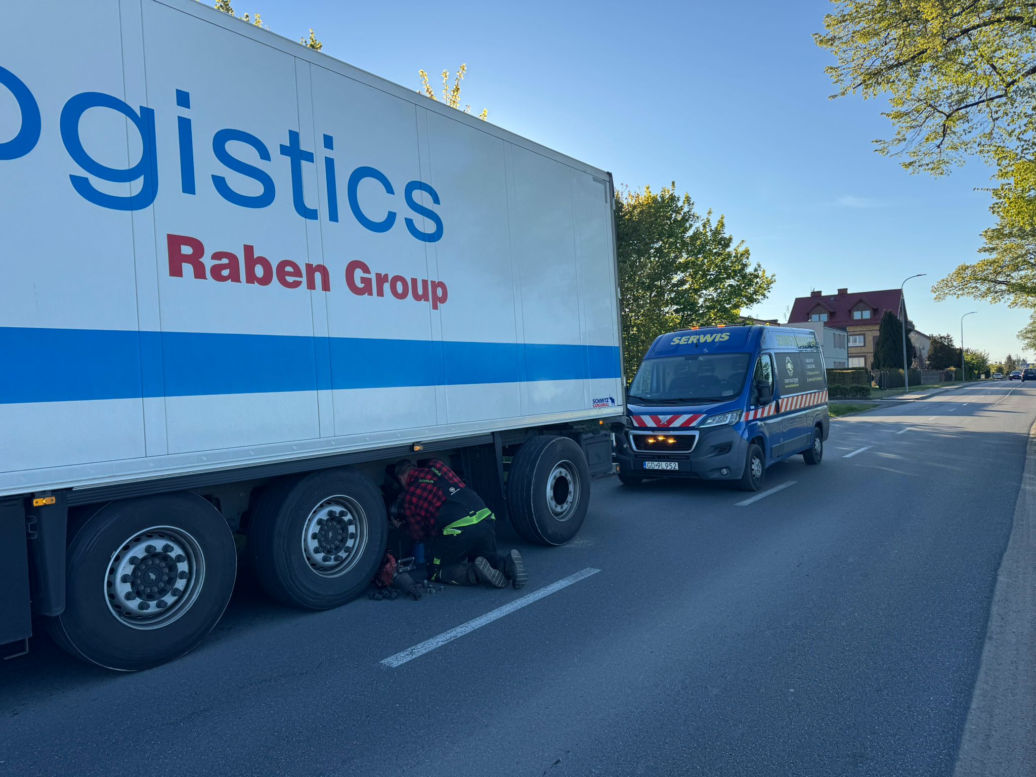 Mechanik naprawiajacy ciężarówkę na drodze